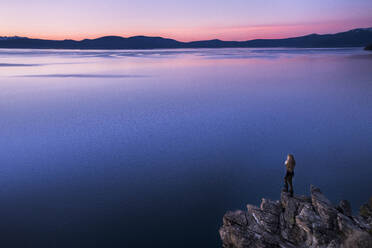 Junge Frau mit Blick auf den Lake Tahoe bei Sonnenuntergang - CAVF94585