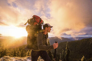 Side view of man backpacking on mountain ridge with scenic view. - CAVF94608