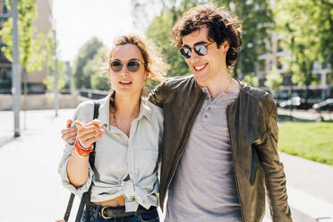 Couple walking on footpath on sunny day - MEUF03197