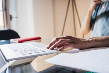 Mann benutzt Laptop bei der Arbeit zu Hause - MEUF03281