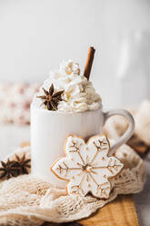 Weihnachtsplätzchen in Form einer Schneeflocke und eine Tasse mit heißem, schaumigem Chai - FLMF00569