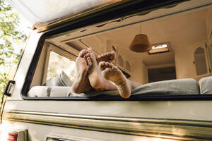 Young couple's feet on motor home window - VPIF04382
