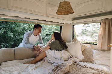 Loving young couple looking at each other through motor home window - VPIF04386