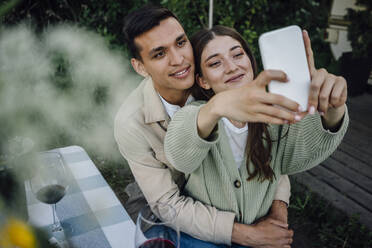 Young couple taking selfie through mobile phone - VPIF04409