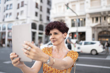 Reife Frau nimmt Selfie durch digitale Tablet in der Stadt - JCCMF03102