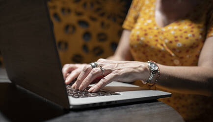 Frau mit Laptop am Tisch in einem Kaffeehaus - JCCMF03112