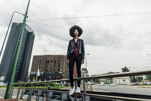 Thoughtful woman standing on railing in city - MEUF03307