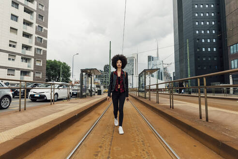 Young woman walking on tramway in city - MEUF03312