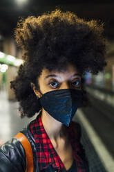 Frau mit Gesichtsmaske in der U-Bahn-Station während COVID-19 - MEUF03392