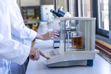 Wissenschaftlerin wiegt Chemikalien auf einer Waage im Labor - DLTSF01991