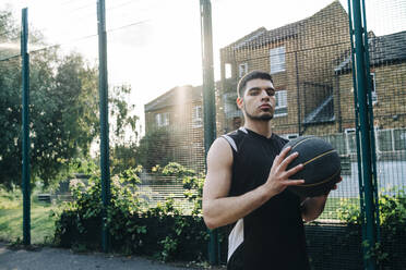 Ernsthafter Basketballspieler auf dem Sportplatz - ASGF00781