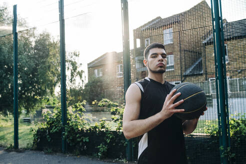 Ernsthafter Basketballspieler auf dem Sportplatz - ASGF00781