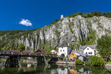Deutschland, Bayern, Essing, Stadt am Ufer der Altmuhl mit steilem Felsen im Hintergrund - MABF00582