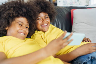 Glückliche Zwillingsbrüder benutzen ihr Smartphone zu Hause - MEUF03400