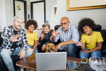 Multi-ethnic family greeting during video call on laptop at home - MEUF03405