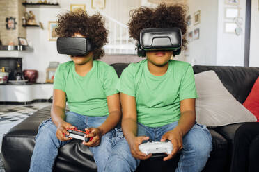 Zwillingsbrüder spielen mit einer Virtual-Reality-Brille zu Hause - MEUF03416