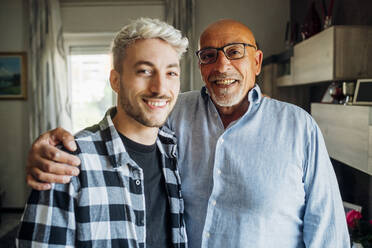 Lächelnder Vater mit seinem Sohn zu Hause - MEUF03429