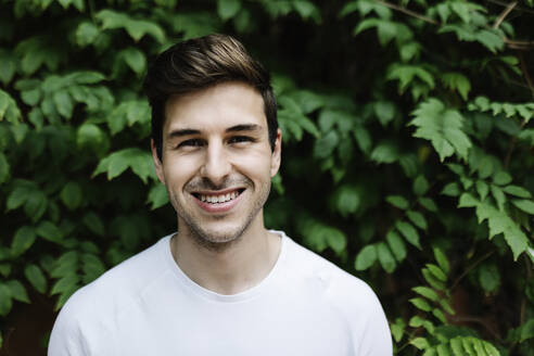 Smiling handsome man in front of tree - XLGF02098