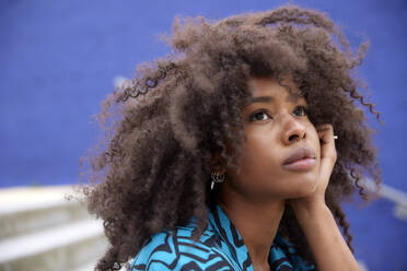 Thoughtful Afro woman with hand on chin - FMKF07266