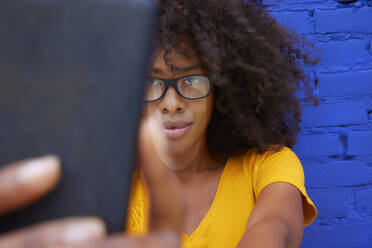 Afro woman taking selfie through smart phone - FMKF07304