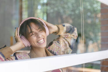 Cheerful woman listening music in studio - IFRF00932