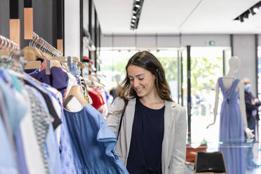 Lächelnde Frau beim Einkaufen in einer Boutique - EIF01532