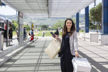 Frau mit Einkaufstaschen an der Straßenbahnhaltestelle - EIF01590