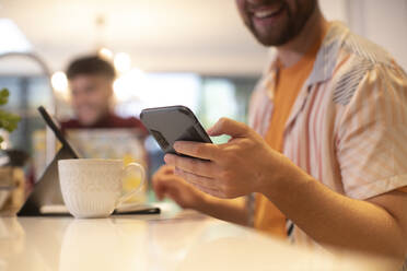 Close up young man using smart phone at home - CAIF31111