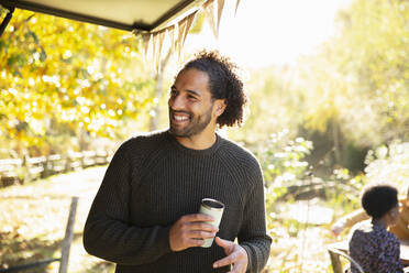 Glücklicher Mann mit Kaffee im sonnigen Herbstpark - CAIF31291