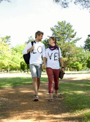 Junges Paar hält sich beim Spaziergang im öffentlichen Park an den Händen - AJOF01506