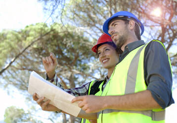 Female engineer discussing with male colleague holding document - AJOF01509