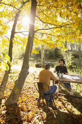 Geschäftsleute treffen sich an einem Tisch im sonnigen Herbstpark - CAIF31341