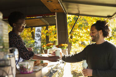 Food cart owner serving coffee to customer - CAIF31363