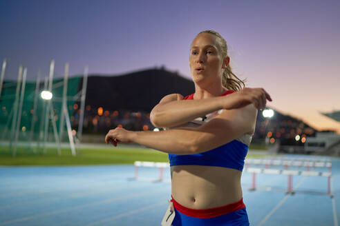 Female track and field athlete preparing for competition on track - CAIF31379