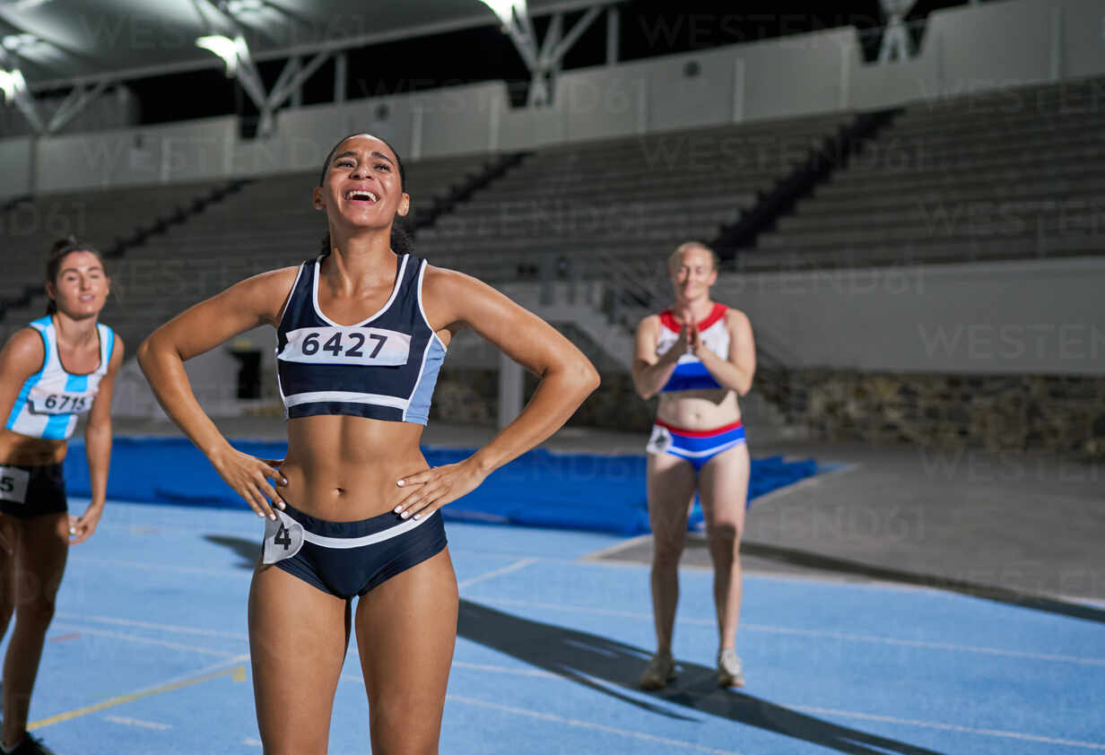 Tired female track and field athletes in stadium stock photo