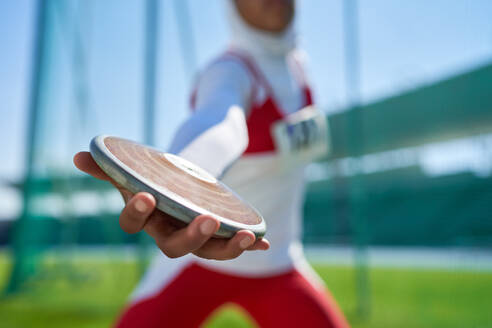 Close up female track and field athlete throwing discus - CAIF31415