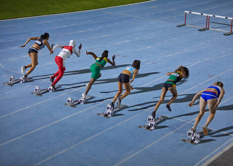 Female track and field athletes at starting blocks - CAIF31430