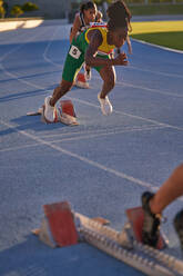 Determined female track and field athlete taking off at starting block - CAIF31452