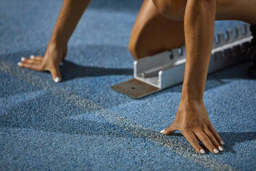 Close up female track and field athlete at starting block - CAIF31465