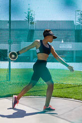 Female track and field athlete throwing discus - CAIF31495