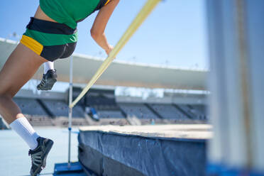 Female track and field athlete high jumping over pole - CAIF31522