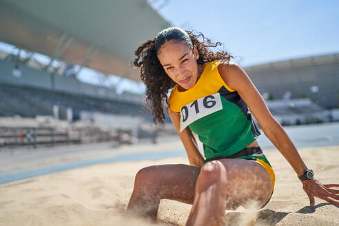 Weibliche Leichtathletin beim Weitsprung im Sand - CAIF31525