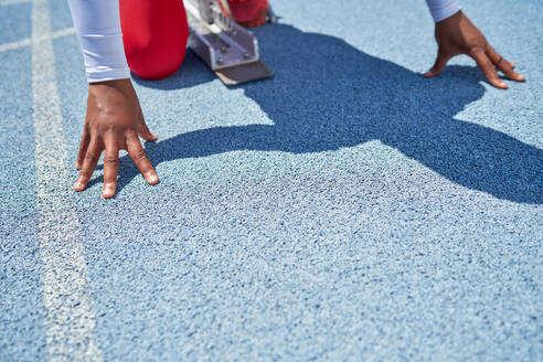 Close up hands of female track and field athlete at starting block - CAIF31532