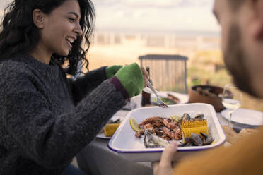 Paar genießt Mittagessen mit Meeresfrüchten auf der Terrasse - CAIF31607