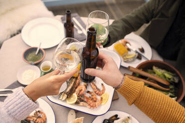 Pärchen stößt bei Wein und Bier auf ein Mittagessen mit Meeresfrüchten an - CAIF31660