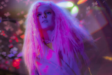 Porträt selbstbewusste Frau mit rosa Haaren in einem Nachtclub - CAIF31745