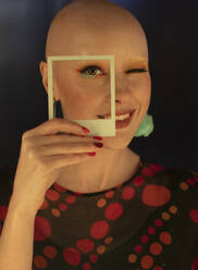Porträt modische Frau mit rasiertem Kopf und Polaroid-Ausschnitt - CAIF31766