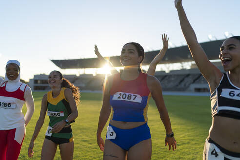 Glückliche Leichtathletinnen feiern im sonnigen Stadion - CAIF31785