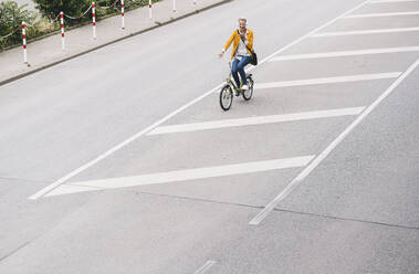 Weiblicher Profi fährt Fahrrad auf der Straße - UUF23959