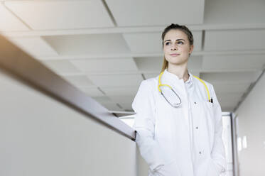 Germany, Bavaria, Munich, Young female doctor standing in corridor - ISF24711